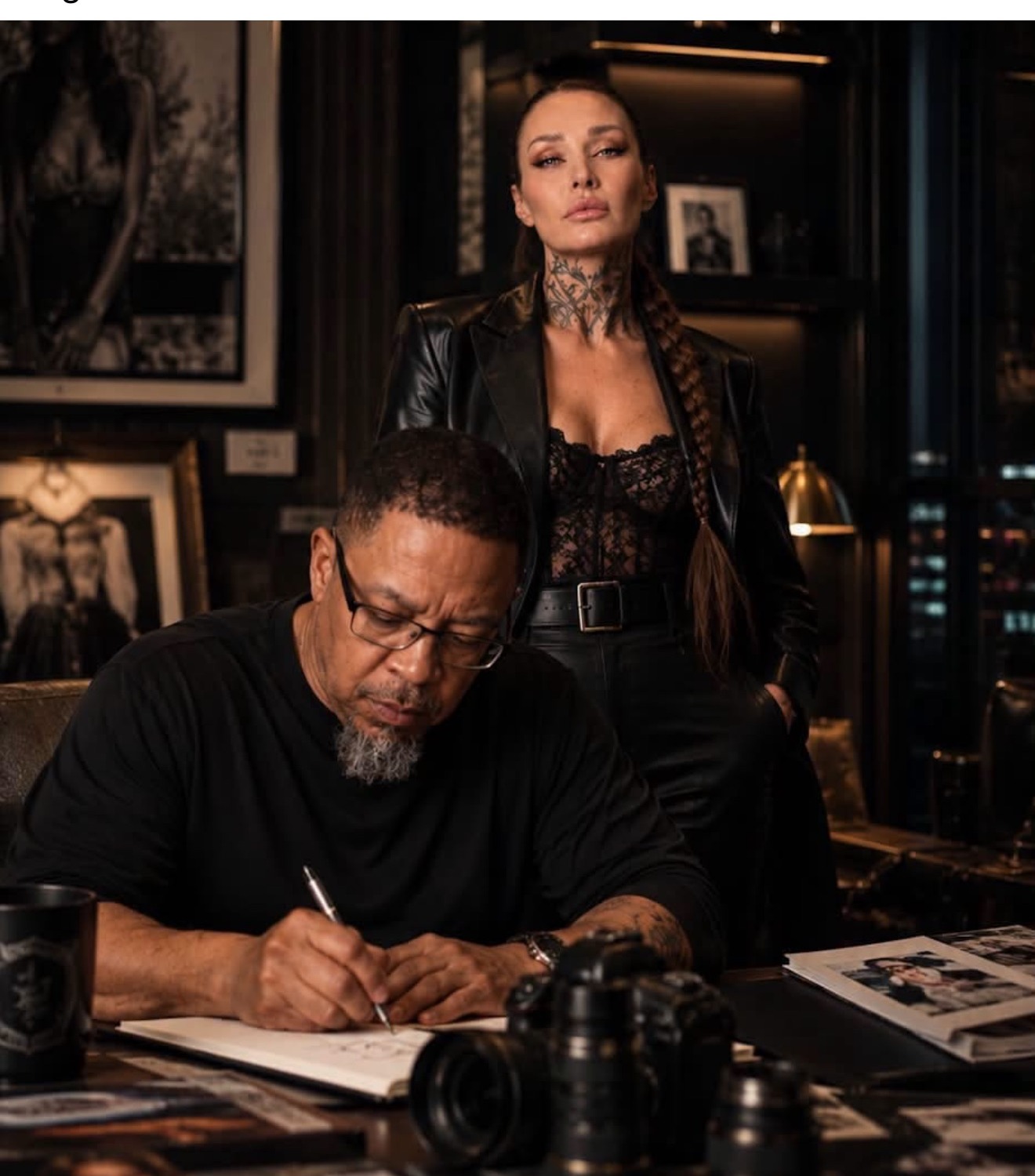 Vilma Biliene Coleman standing with Chuck Coleman as he writes at a desk
